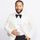John Legend in a white tuxedo and black bowtie posing for a photo.